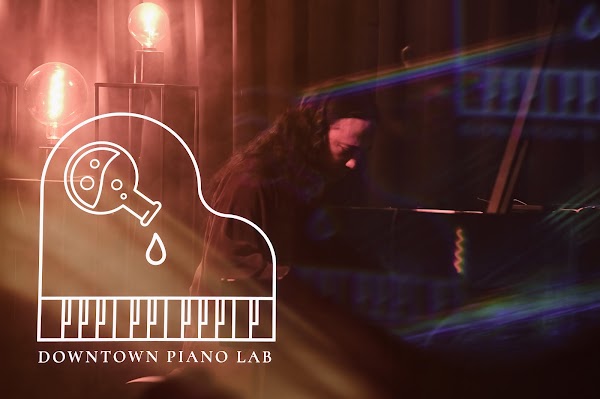 Downtown Piano Lab ženklas scenos šviesų atspindyje